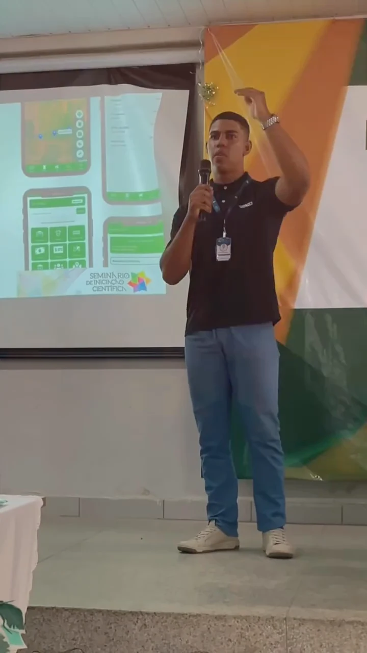 Integrante da equipe do Finagro apresenta o projeto na SEMIC do IFMA Campus Pedreiras, com telas do aplicativo no telão
