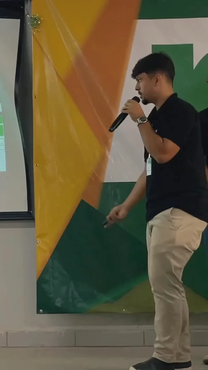 Integrante da equipe aponta para o telão durante a apresentação
