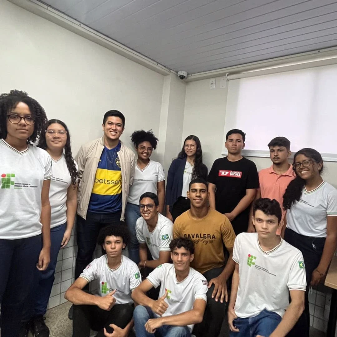 Grupo de estudantes e professores posa em sala do campus