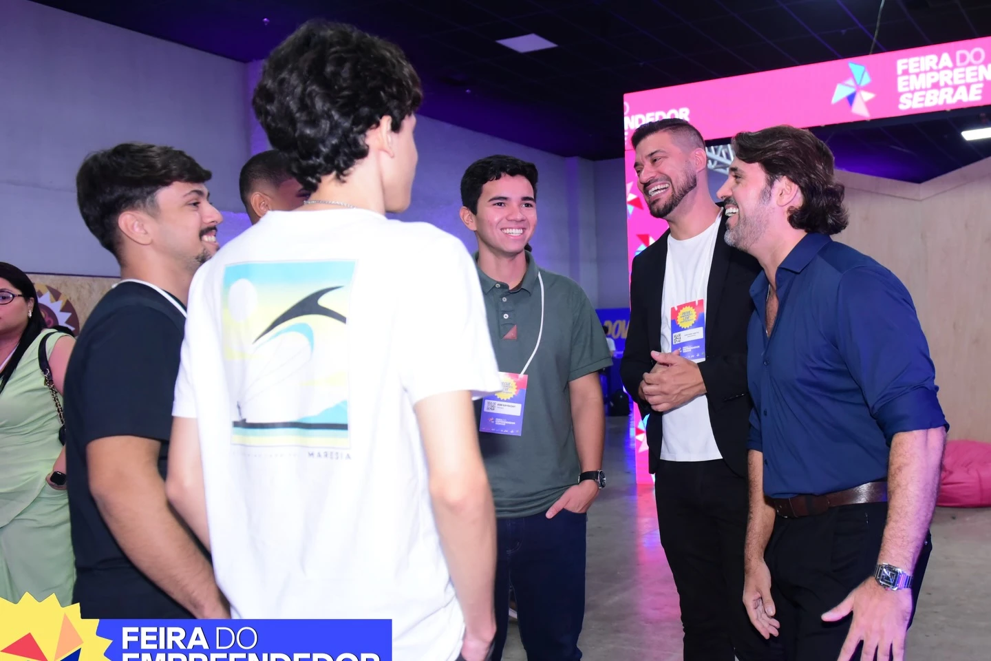 Integrantes da equipe e participantes conversam no pavilhão da feira